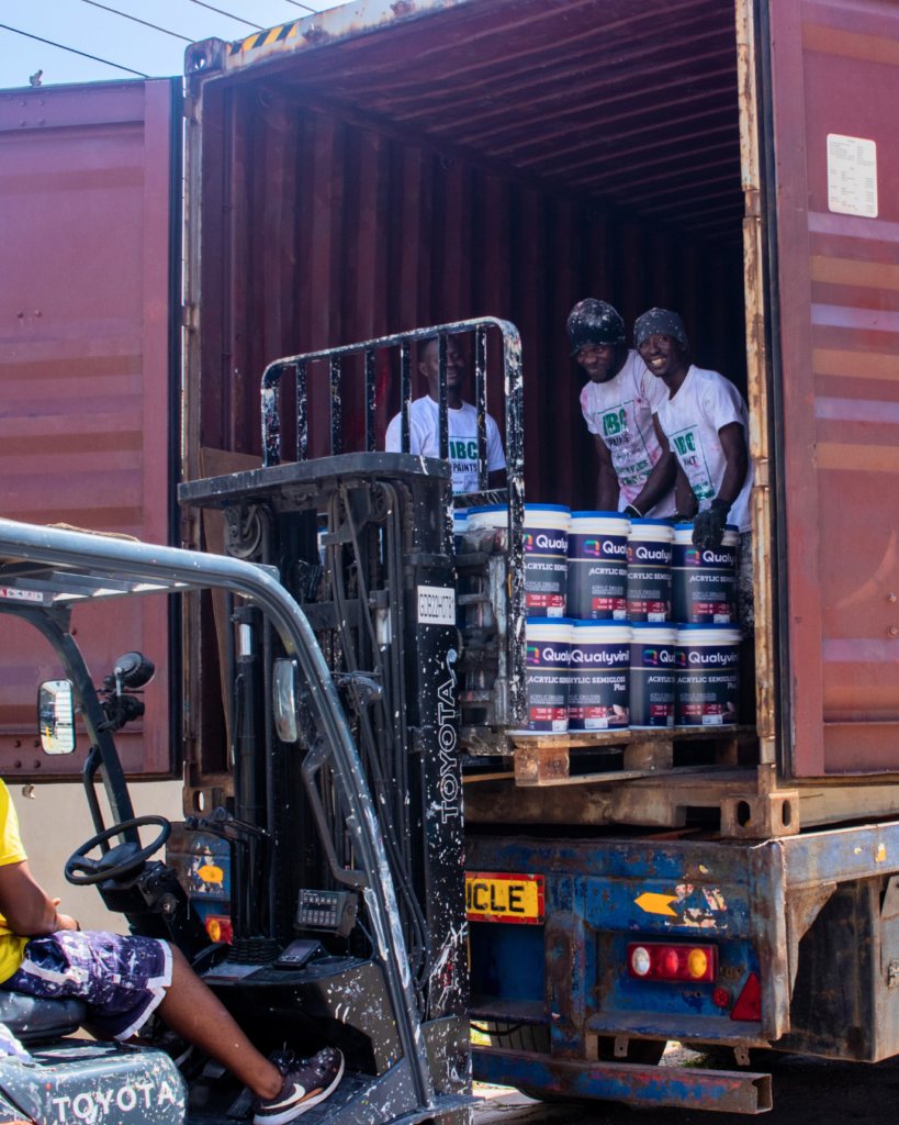Team offloading a container of paint